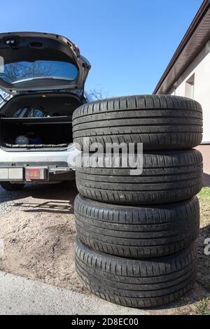 Quattro ruote grandi con pneumatico estivo sono pronte per il carico all'interno del bagagliaio dell'autovettura Foto Stock