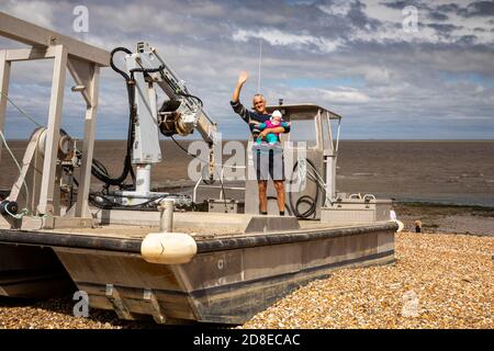 Regno Unito, Kent, Whitstable, Harbour, East Quay, uomo con bambino su ostriche barca da pesca Foto Stock