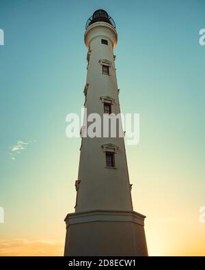 Alto faro al tramonto sulla costa di Aruba Foto Stock