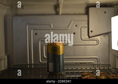 Birra in frigorifero, frigorifero vintage aperto che mostra l'interno con luce interna e scaffale con lattina di birra fredda Foto Stock