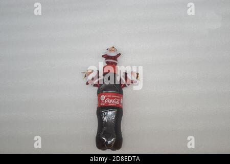 Bottiglia di plastica Coca Cola in formato promozionale con ornamento natalizio con Babbo Natale su sfondo bianco, con prezzo promozionale Foto Stock