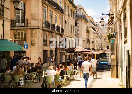 Strada trafficata con caffè all'aperto a Baixa, Lisbona, Portogallo, Europa. Foto Stock