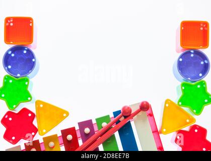 Blocchi colorati per scatola di smistamento con strumento musicale xilofono per bambini, cornice piatta con spazio vuoto, sfondo bianco Foto Stock