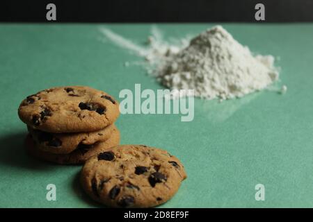 due o più biscotti con gocce di cioccolato stanno sdraiandosi accanto l'uno all'altro e una collina su un'erba verde sfondo dietro sullo sfondo è una collina di flo Foto Stock