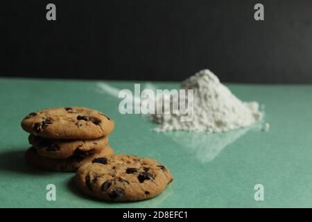 due o più biscotti con gocce di cioccolato stanno sdraiandosi accanto l'uno all'altro e una collina su un'erba verde sfondo dietro sullo sfondo è una collina di flo Foto Stock