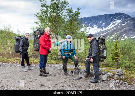 Coppia senior con figli giovani e adulti pronti a iniziare il loro percorso escursionistico in montagna, persone che guardano la macchina fotografica Foto Stock