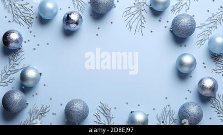 Cornice di Natale. Palline di Natale in colori pastello e decorazioni in argento su sfondo blu. Disposizione piatta, vista dall'alto. Biglietto d'auguri di Natale design, banne Foto Stock