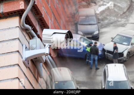 Telecamera TVCC montata a parete per la registrazione di incidenti stradali o incidenti stradali, collage con auto e persone sfocate Foto Stock