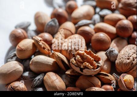 dadi assortiti. Diversi tipi di noci di macadamia, noci e nocciole giacciono in uno strato uniforme. Sfondo dei dadi Foto Stock