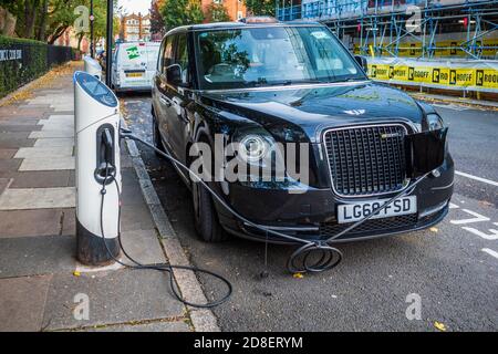 Ricarica di taxi elettrici - LECV TX Ecity London ricarica di taxi elettrici presso una stazione di ricarica sul marciapiede. Foto Stock