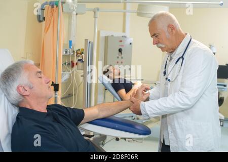 medico maschile che raccoglie il sangue dal paziente Foto Stock