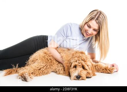 Donna con il suo cane Labradoodle d'oro isolato su sfondo bianco Foto Stock