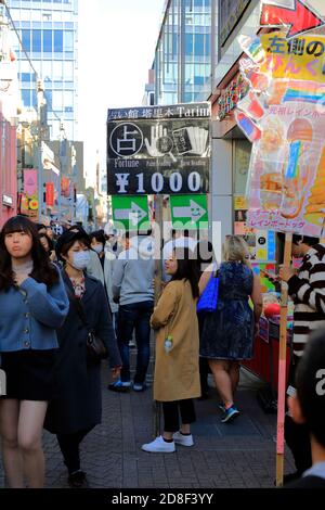 Una giovane donna che tiene un cartello per dire fortuna In Takeshita Street.Harajuku.Shibuya.Tokyo.Japan Foto Stock