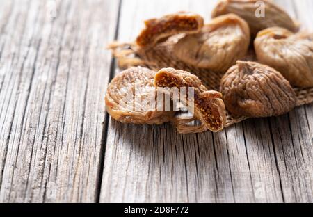 Fichi secchi posti su un vecchio sfondo di legno con spazio Foto Stock