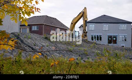 Escavatore in un nuovo sito di costruzione di abitazioni. Foto Stock