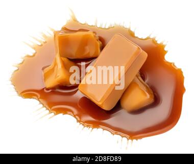 Composizione di caramelle morbide isolate su sfondo bianco, vista dall'alto. Pezzi di caramello dolce con salsa o sciroppo d'acero Foto Stock