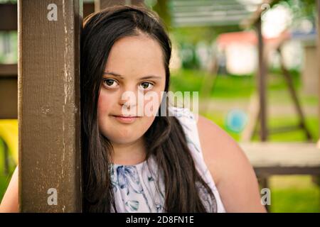 Un Ritratto di trisomia 21 ragazza adulta fuori al tramonto Foto Stock