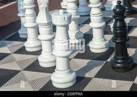 Grande scacchi di strada su scacchiera gigante nel parco esterno. Grandi scacchi di plastica. Messa a fuoco selettiva. Foto Stock