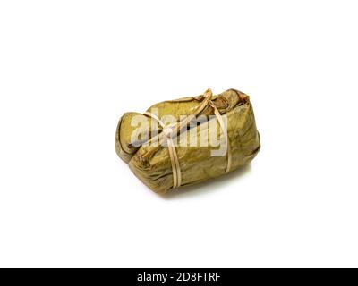 Il primo piano di riso thai al vapore appiccicoso con latte di cocco e banana (Khao Tom Mud) avvolto da foglie di banana su sfondo bianco. Foto Stock