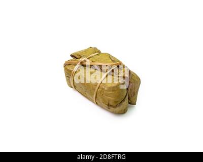 Il primo piano di riso thai al vapore appiccicoso con latte di cocco e banana (Khao Tom Mud) avvolto da foglie di banana su sfondo bianco. Foto Stock