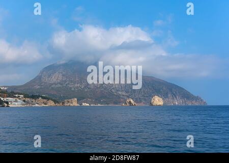 Mount Bear Ayu-Dag sotto le nuvole da vicino. Vista delle rocce di adalara ai piedi della montagna e la costruzione del campo per bambini Artek. Au Foto Stock