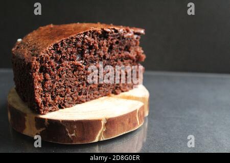 torta brownie di cioccolato su un supporto di legno in un nero con spazio per la copia del testo Foto Stock