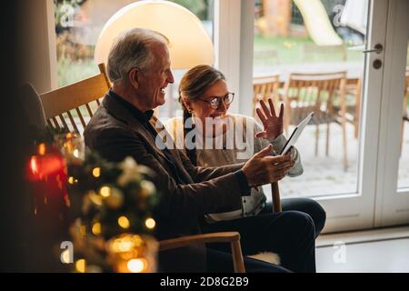 Famiglia che ha una videochiamata sul PC da tavolo durante natale. Una coppia di anziani saluta la famiglia durante una videochiamata alla vigilia di Natale. Foto Stock