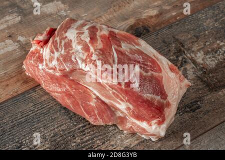 carne di maiale cruda. collo di maiale su fondo di legno scuro. filetto di maiale pronto per la cottura Foto Stock