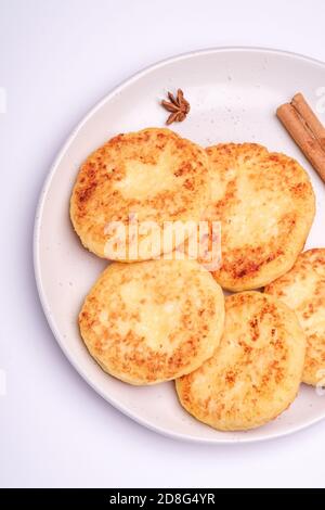 Frittelle di formaggio di cottage. Colazione di Natale con anice e cannella su sfondo bianco, vista dall'alto Foto Stock