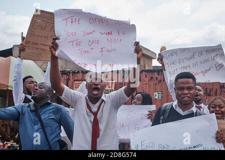 Le persone sollevano pugni e cartelli durante le proteste contro la brutalità della polizia ha etichettato EndSARS a Lagos Nigeria il 20 ottobre 2020. Foto Stock