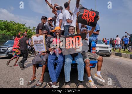 Le persone sollevano pugni e cartelli durante le proteste contro la brutalità della polizia ha etichettato EndSARS a Lagos Nigeria il 2020 ottobre. Foto Stock