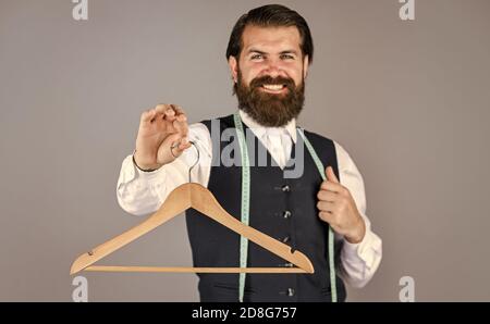 per te. uomo su misura usa metro a nastro. sartor professionale maschio con metro a nastro e appendiabiti. Bell'uomo in abbigliamento casual elegante sta reggendo l'appendiabiti. Ritratto di uomo che tiene l'appendiabiti. Foto Stock