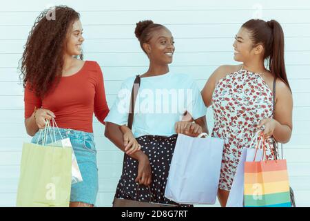 Felice gruppo di amici shopping in primavera e estate stagione. Una foto di un gruppo di ragazze felici che acquistano in città. Sfondo bianco. Shopping e. Foto Stock