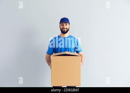 Buon corriere maschio sorridente per la macchina fotografica Foto Stock
