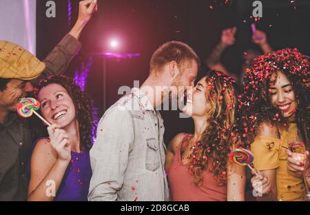 Gruppo di amici felici che fanno festa in nightclub - giovani persone che si divertono a festeggiare e ballare insieme in discoteca club Foto Stock