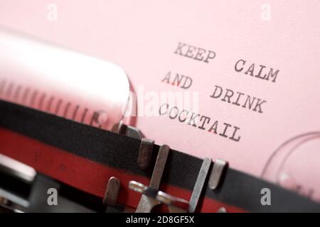 Mantenere calma e bere cocktail frase scritta con una macchina da scrivere. Foto Stock