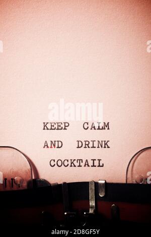 Mantenere calma e bere cocktail frase scritta con una macchina da scrivere. Foto Stock
