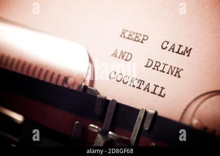 Mantenere calma e bere cocktail frase scritta con una macchina da scrivere. Foto Stock