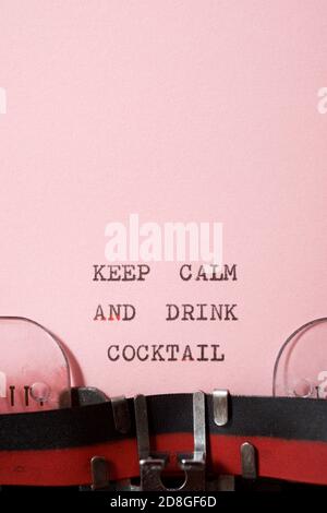Mantenere calma e bere cocktail frase scritta con una macchina da scrivere. Foto Stock