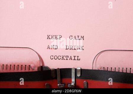 Mantenere calma e bere cocktail frase scritta con una macchina da scrivere. Foto Stock