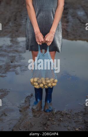 Donna che tiene il sacchetto della stringa con le patate. Foto Stock