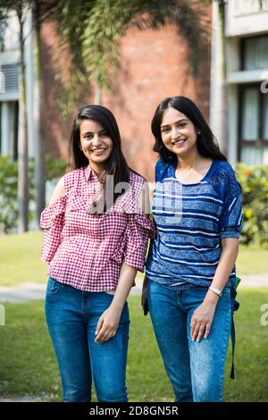 Due studenti di collage indiani asiatici o amici che posano per fotografare nel campus, all'aperto Foto Stock