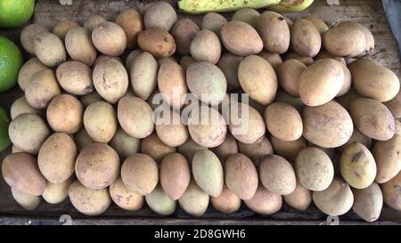 Vista in primo piano della frutta fresca rifornita Chikoo, Manilkara zapota comunemente noto come saodilla, sapota, chikoo Foto Stock