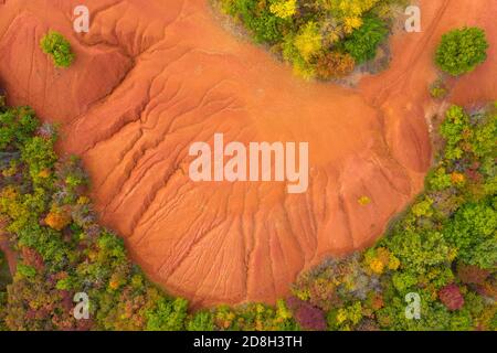 Gant, Ungheria - Vista aerea della miniera abbandonata di bauxite, formazione di bauxite. Superficie di colore rosso e arancione, grana bauxite. Caldi colori autunnali. Foto Stock