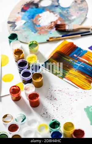 pitture di gouache, pennelli e pennellate astratte colorate su carta su sfondo bianco Foto Stock