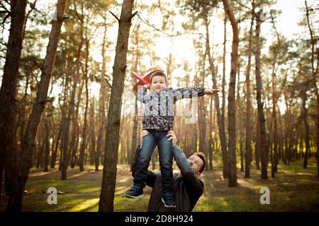 Divertente. Padre e figlio che camminano e si divertono nella foresta d'autunno, sembrano felici e sinceri. Laughting, giocare, avere buon tempo insieme. Concetto di famiglia, felicità, vacanze, infanzia, stile di vita. Foto Stock