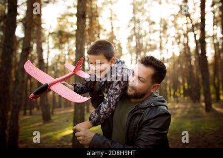 Emozioni. Padre e figlio che camminano e si divertono nella foresta d'autunno, sembrano felici e sinceri. Laughting, giocare, avere buon tempo insieme. Concetto di famiglia, felicità, vacanze, infanzia, stile di vita. Foto Stock