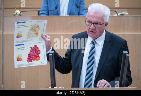 Stoccarda, Germania. 30 Ott 2020. Winfried Kretschmann (Bündnis 90/Die Grünen), Ministro Presidente del Baden-Württemberg, presenta due mappe che mostrano l'incidenza di sette giorni di infezioni da corona alla fine di settembre (inizio pagina) e la fine di ottobre (fine pagina) durante la 130a sessione del 16° Parlamento del Baden-Württemberg. Nella sessione speciale, il governo informerà il parlamento in seguito alla conferenza del Cancelliere con i capi di governo dell'Länder sulla pandemia corona. Credit: Sebastian Gollnow/dpa/Alamy Live News Foto Stock