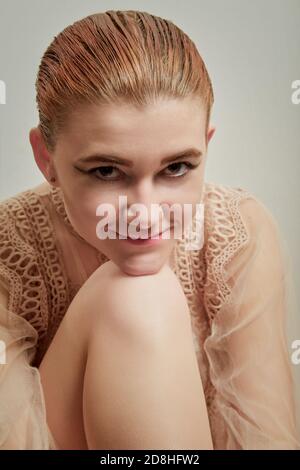 giovane transgender con la cosmesi femminile sorride, guarda la macchina fotografica, immagine closeup Foto Stock