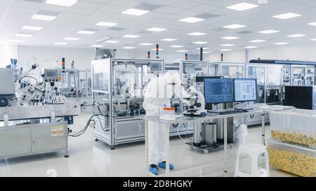 Shot of sterile Pharmaceutical Manufacturing Laboratory dove gli scienziati in Protective Covers fanno Research, controllo di qualità e lavoro sul Foto Stock